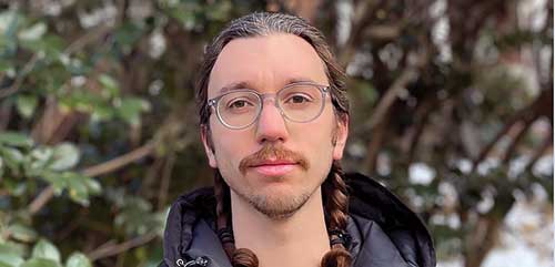 Nick Stavely headshot standing in front of a tree